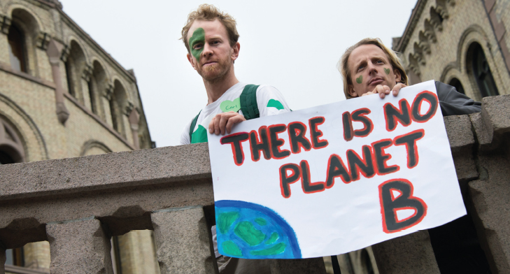 Two people holding a poster saying ‘there is no planet B’